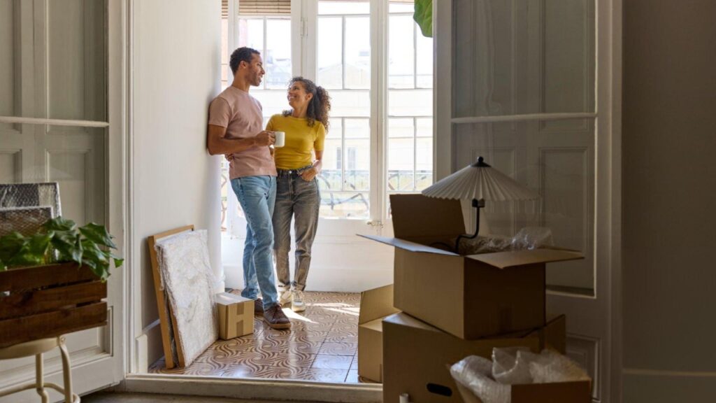 Couple taking a break in their new house after using house moving apps