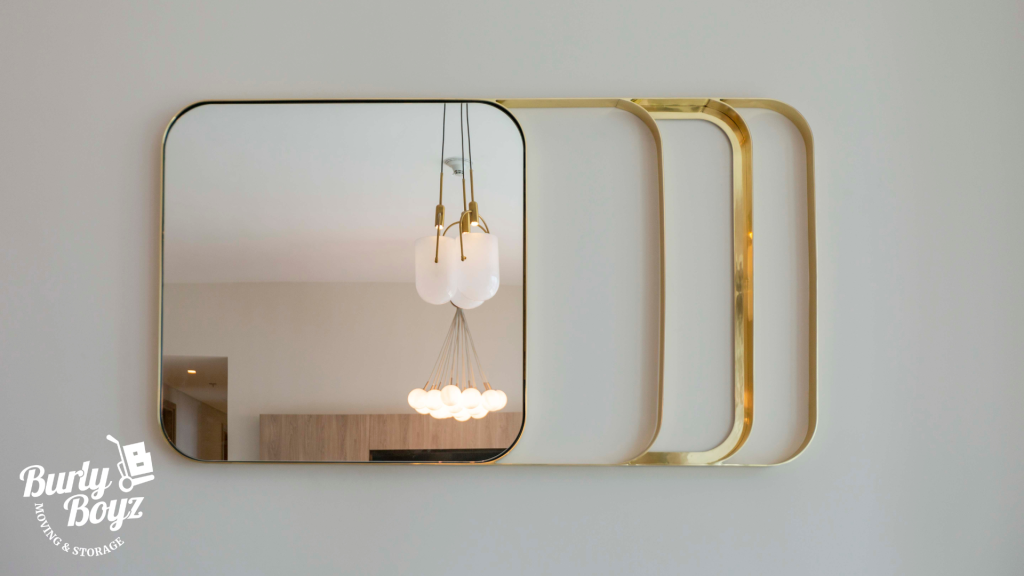Modern glass wall mirror with gold frame — a reminder that reducing moving costs in Ontario also means properly protecting valuables